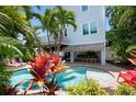 View of the refreshing pool area with tropical plants and lounge chairs at 4805 2Nd Ave, Holmes Beach, FL 34217