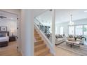 Modern light oak staircase with metal railing, offering views of living room and bedroom at 2446 Floyd St, Sarasota, FL 34239