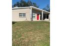 Tan single story home with red door and grassy yard at 3375 8Th St, Sarasota, FL 34237