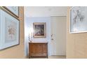 Bright condo entryway with wood cabinet and artwork at 1750 Benjamin Franklin Dr # 2G, Sarasota, FL 34236