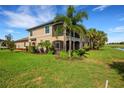 Tan two-story home with a screened porch and lush landscaping at 5830 Wake Forest Run # 104, Bradenton, FL 34211