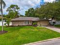 Single-story home with stone exterior, large yard, and attached garage at 4218 Vaughan Ln, Sarasota, FL 34241