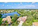 Stunning aerial view of the home overlooking a serene lake and lush greenery in a beautiful neighborhood at 105 New Briton Ct, Bradenton, FL 34212