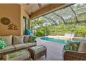 Relaxing screened-in patio featuring comfortable seating and views of the sparkling pool and lush backyard at 105 New Briton Ct, Bradenton, FL 34212