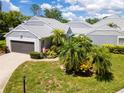 Charming villa with gray siding, lush landscaping, and a two-car garage at 3423 52Nd Avenue W Cir # 267, Bradenton, FL 34210