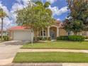 Charming home featuring a well-manicured lawn, mature trees, and a stylish light blue front door at 3108 Royal Palm Dr, North Port, FL 34288