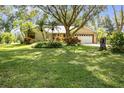 Beautiful single-story home with mature trees, lush landscaping, and a two-car garage, set on a verdant lawn at 1741 Jewel Dr, Sarasota, FL 34240