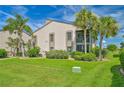 Condo building with lush landscaping and a manicured lawn at 26336 Nadir Rd # 12, Punta Gorda, FL 33983