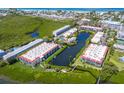 Aerial view of waterfront community with tennis courts and lush landscaping at 3705 E Bay Dr # 115, Holmes Beach, FL 34217