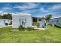 White mobile home with a small patio and grassy yard at 6428 Fleetwood Ct, North Port, FL 34287