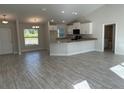 Open kitchen with white cabinets, granite countertops, and gray wood-look tile floors at 8005 Tropicaire Blvd, North Port, FL 34291