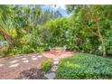 Lush backyard with tropical greenery, stone accents, and a patio dining area perfect for entertaining at 839 40Th St, Sarasota, FL 34234