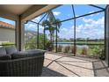 Screened-in patio with comfortable seating and views of the lush landscaping and serene lake at 5709 Puccini St, Nokomis, FL 34275