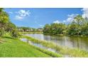 Beautiful backyard view showcasing a serene lake with lush greenery, creating a peaceful and picturesque setting at 7217 Churston Ln, University Park, FL 34201