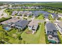 Aerial view of a community with houses, a lake, and lush greenery at 8370 Velda Trl, Sarasota, FL 34241