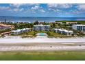 Aerial view of beachfront condo community with pool and lush landscaping at 4825 Gulf Of Mexico Dr # 105, Longboat Key, FL 34228
