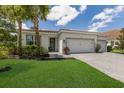 Single-story home with two-car garage, landscaping, and paver driveway at 7291 Great Egret Blvd, Sarasota, FL 34241