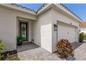 Front entry with paver walkway, potted plants, and a modern door at 7291 Great Egret Blvd, Sarasota, FL 34241