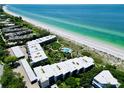 Aerial view of beachfront condo community with pool and lush landscaping at 5757 Gulf Of Mexico Dr # 109, Longboat Key, FL 34228