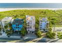 Beachfront property showcasing three modern homes with ocean views at 648 Beach Rd, Sarasota, FL 34242