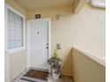 Inviting condo entryway with white door, welcome mat, and potted plant at 1050 Villagio Cir # 206, Sarasota, FL 34237