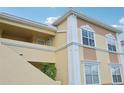 Tan building with white trim, balconies, and stairs, offering a charming exterior at 1050 Villagio Cir # 206, Sarasota, FL 34237