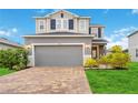 Two-story home with gray siding, a two-car garage and landscaping at 11868 Little River Way, Parrish, FL 34219