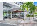 Modern building entrance with palm trees and a paved walkway at 1155 N Gulfstream Ave # 208, Sarasota, FL 34236