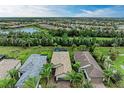 Aerial view of three homes with tile roofs and brick driveways, showcasing a desirable community at 17006 Hampton Falls Ter, Lakewood Ranch, FL 34202