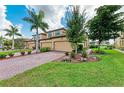 Beautiful two-story home showcasing a three-car garage, manicured lawn, and vibrant landscaping at 6708 Grand Estuary Trl # 104, Bradenton, FL 34212