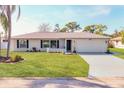 Charming single-story home boasts a fresh exterior, attached garage, and a lush front lawn adding to its curb appeal at 2806 67Th W St, Bradenton, FL 34209