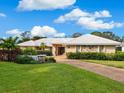 Landscaped yard, single-story home with a double-car garage and stone accents at 5050 Kestral Park S Way, Sarasota, FL 34231