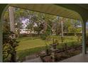 Covered patio view of the spacious backyard, lush landscaping, and mature trees at 2403 Palma Sola Blvd, Bradenton, FL 34209