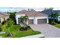 White house with brown roof, two-car garage, and lush landscaping at 284 Corelli Dr, Nokomis, FL 34275