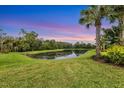 Peaceful backyard oasis with scenic pond view at sunset at 6912 Gosport Cv, Lakewood Ranch, FL 34202