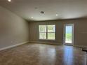 Spacious living room with tile floors, recessed lights, and access to the backyard at 1010 Huntington St, North Port, FL 34288