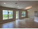 Bright living room with tile floors, recessed lighting, and rear yard access at 1010 Huntington St, North Port, FL 34288