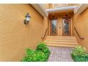 Front entrance with double doors, lush landscaping, brick walkway at 323 Winding Brook Ln # 102, Bradenton, FL 34212