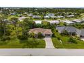 An aerial view of a home with mature landscaping, a long driveway, and a glimpse of the community at 8993 Bantry Bay Blvd, Englewood, FL 34224