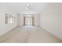 Large, empty living room with a ceiling fan and double doors leading outside at 8993 Bantry Bay Blvd, Englewood, FL 34224