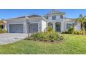 Two-story house with gray walls, gray roof, and landscaping at 21285 Holmes Cir, Venice, FL 34293