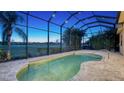 Kidney-shaped pool with a screened enclosure and golf course views at 14717 Leopard Creek Pl, Lakewood Ranch, FL 34202