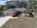 Inviting single-story home featuring a well-maintained lawn and mature palm trees at 4337 Mermell Cir, North Port, FL 34291