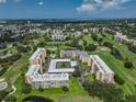 Expansive aerial view of a condo community nestled on a lush green golf course with ponds and scenic landscaping at 4480 Fairways Blvd # 109, Bradenton, FL 34209