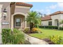 Home's exterior features an arched entryway and manicured landscaping at 212 Casalino Dr, Nokomis, FL 34275