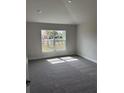 Bedroom featuring a large window providing natural light and plush carpeting at 2628 Averland Loop, North Port, FL 34287