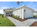 One-story home with white exterior, two-car garage, and landscaped front yard at 1119 Waterline Ct, Sarasota, FL 34240