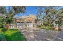 House exterior featuring a two-car garage, manicured lawn, and a brick driveway at 5309 Hidden Harbor Rd, Sarasota, FL 34242