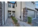 Front entry of townhome with stonework and walkway at 4564 Almada Ln, Wesley Chapel, FL 33543