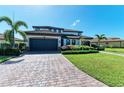Two-story home with dark garage doors, paver driveway and manicured lawn at 14118 Florida Rosemary Dr, Bradenton, FL 34211